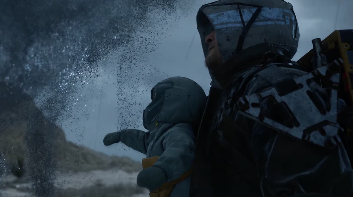 A man with hood and a baby strapped to his chest in Death Stranding 2.