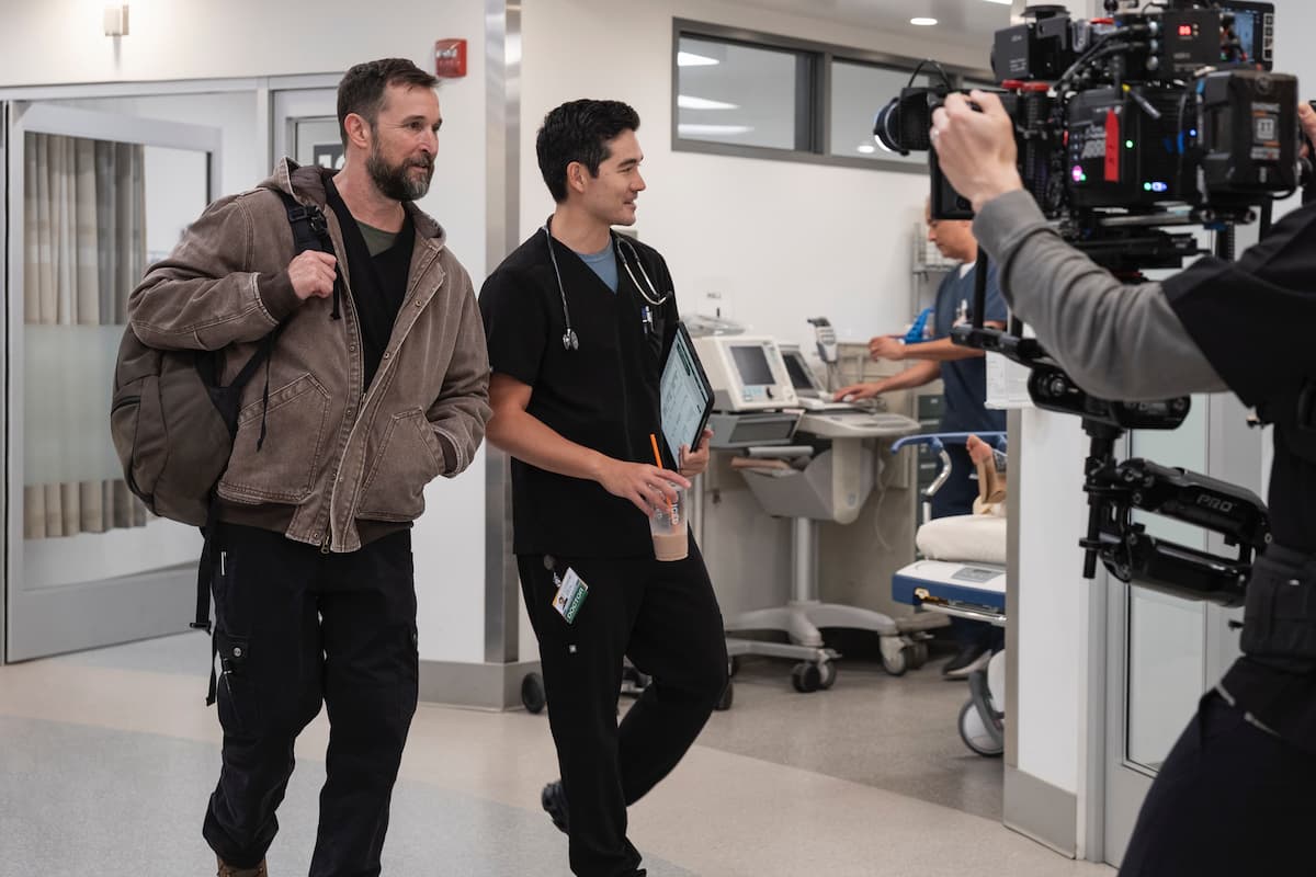 The Pitt Season 2 BTS shot. Two men with dark hair walking into an ER.