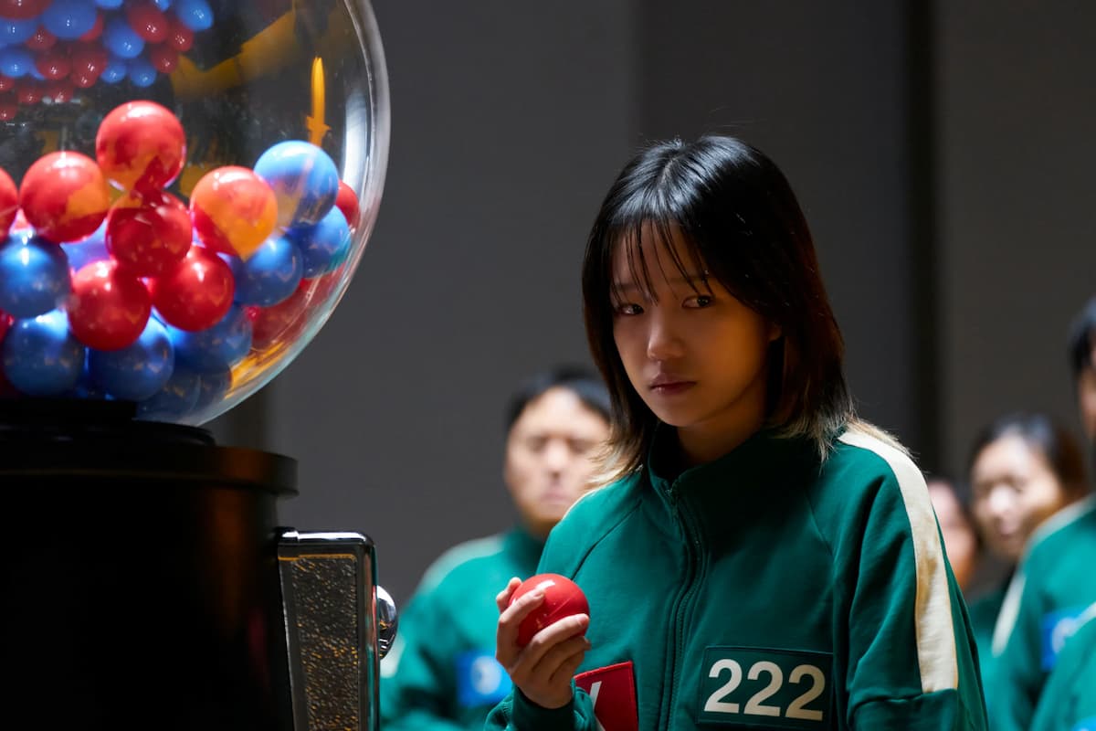 A girl in a green jumpsuit with the number 222 on it.