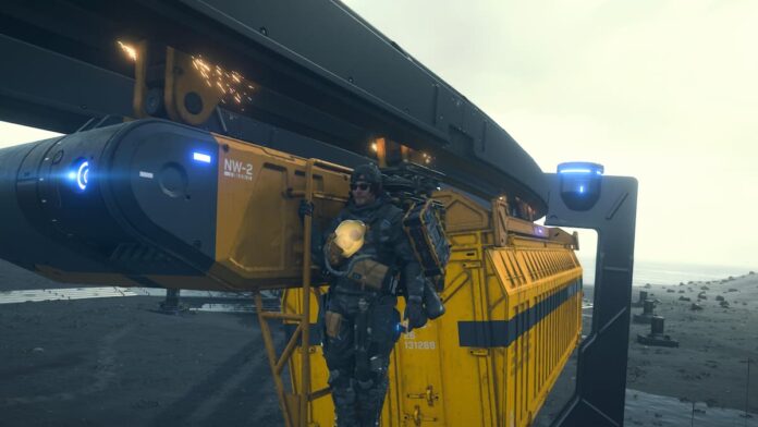 death stranding 2 monorail A man hanging onto a monorail with a yellow container behind him.
