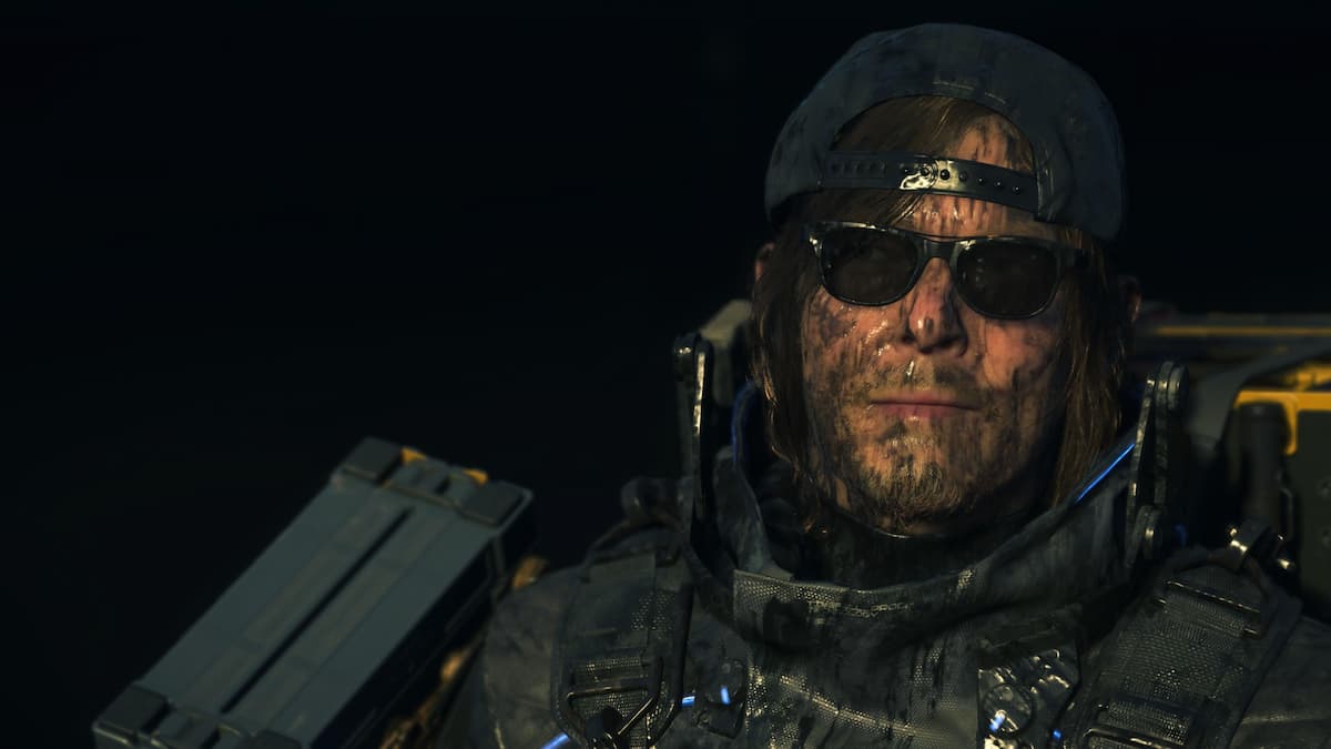 A man wearing a cap backwards and sunglasses.