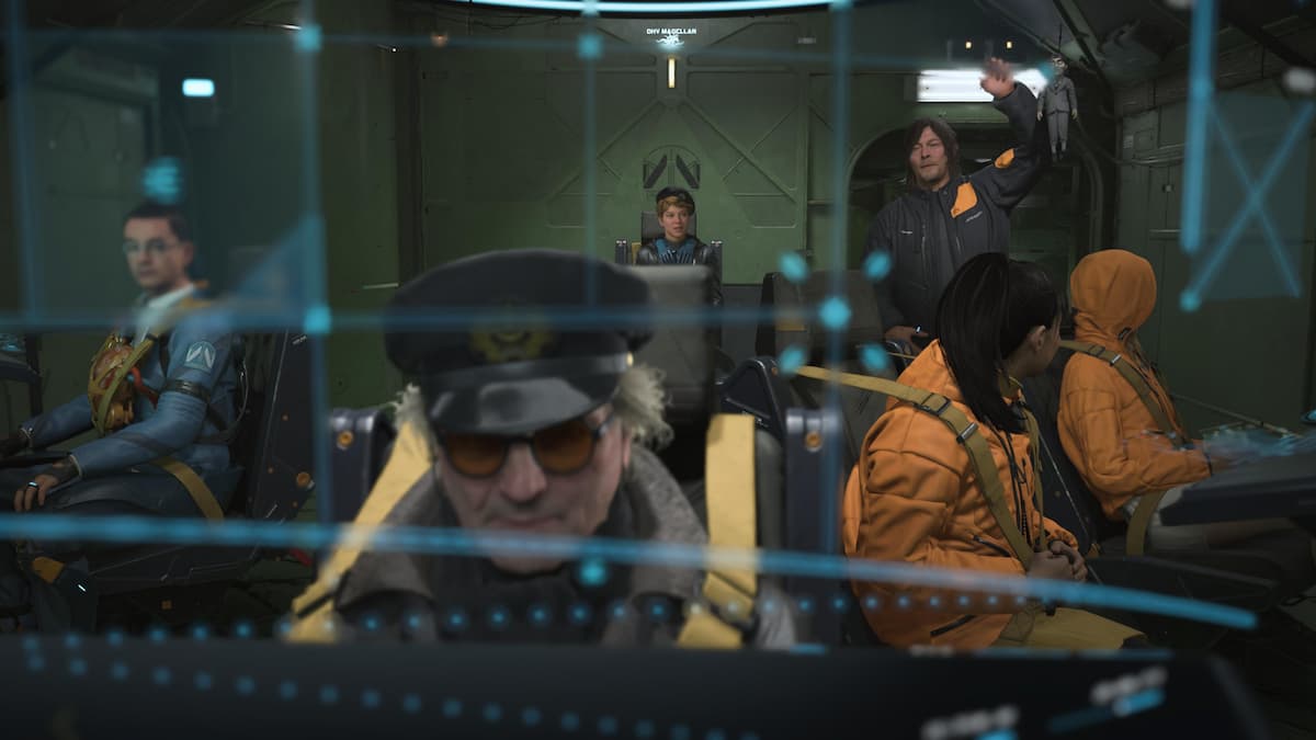 A man with a captain's hat and glasses sitting down, with five crew members in the background.