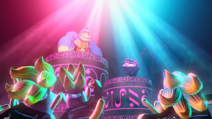 dk concert A monkey standing on top of a podium under pink and blue lights for our Donkey Kong Bananza review.