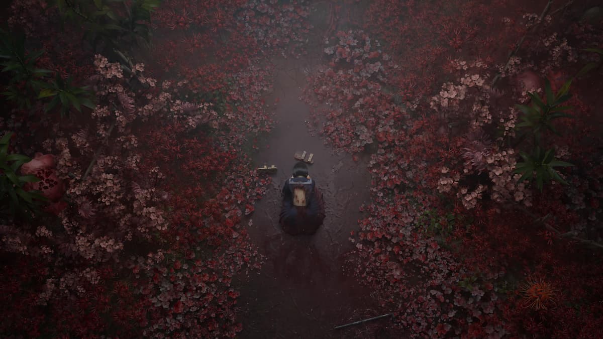 A girl lying among red flowers. Cover image for our Silent Hill f review.