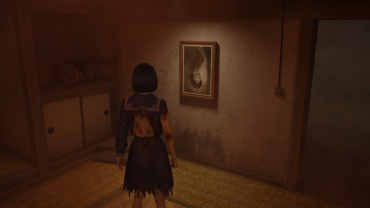 A girl looking at an upside-down photo as one of the Silent Hill f puzzles.