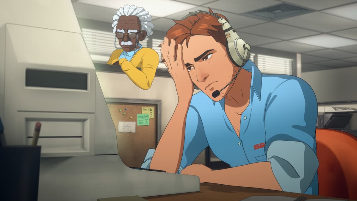 A man sitting at a desk with his head resting on his hand.