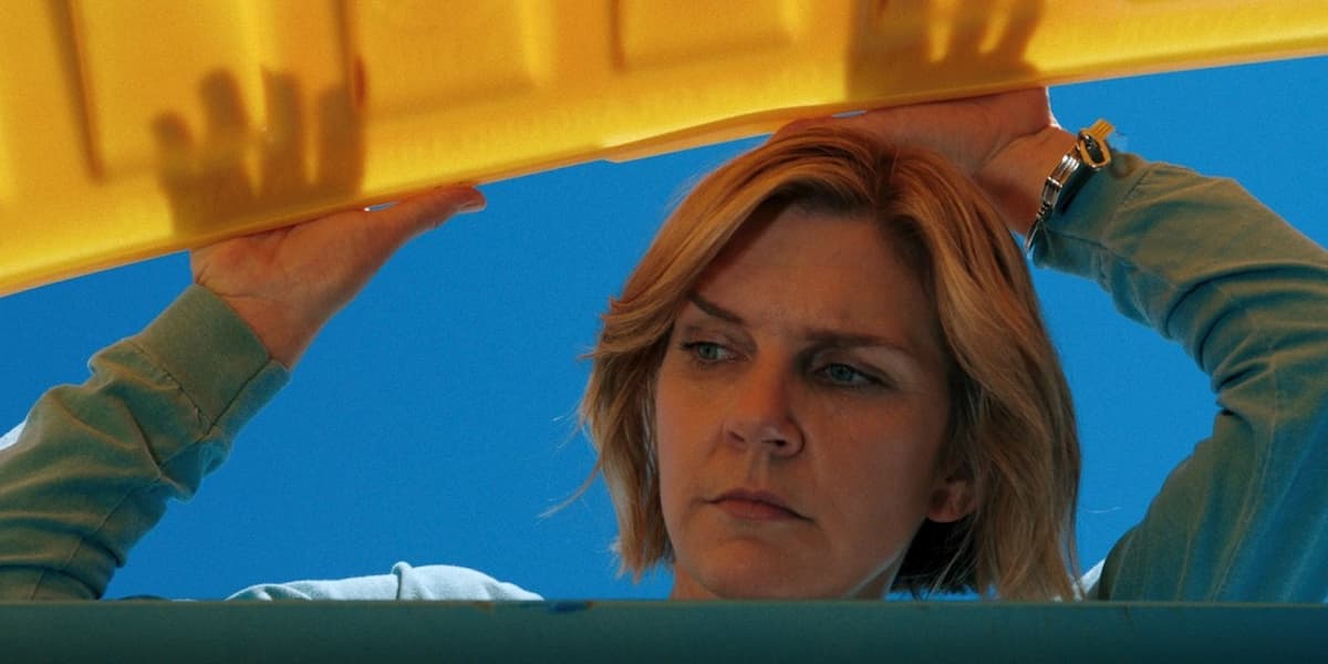 A woman looking through a recycle bin in Pluribus.