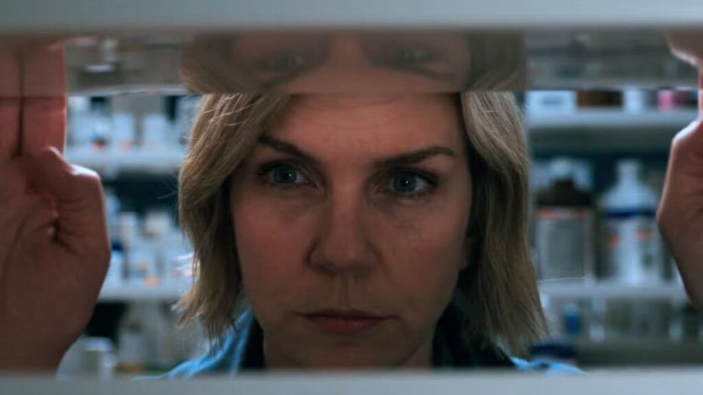 A close-up of a woman through a shelf.