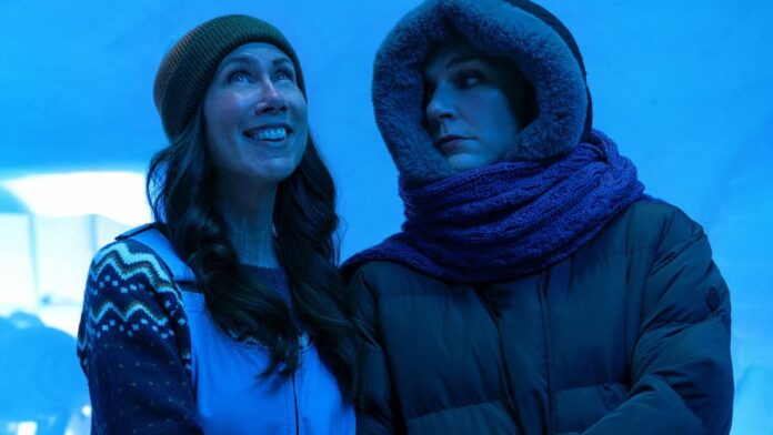 pluribus ice hotel Two women dressed warmly against a blue background.