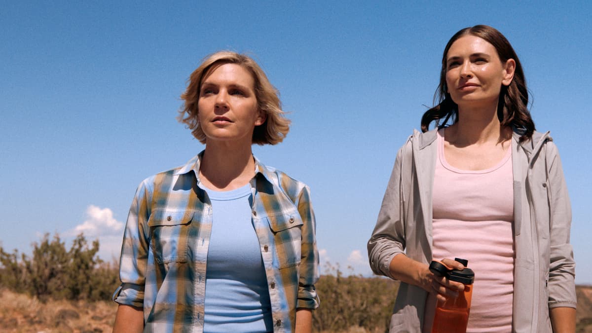 Two women standing in the desert.
