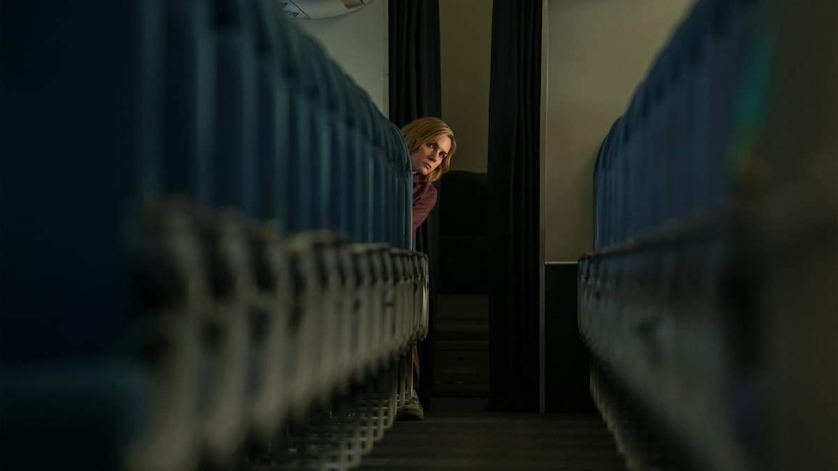 A woman looking down the airplane aisle in Pluribus.