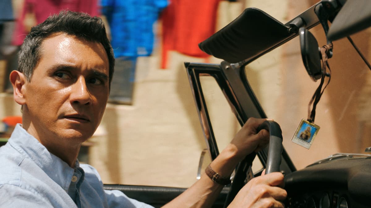 A man driving a car and looking out.