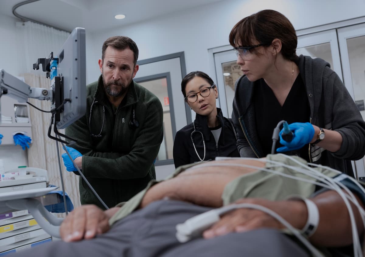 A man and a woman looking at a patient in The Pitt Season 2.
