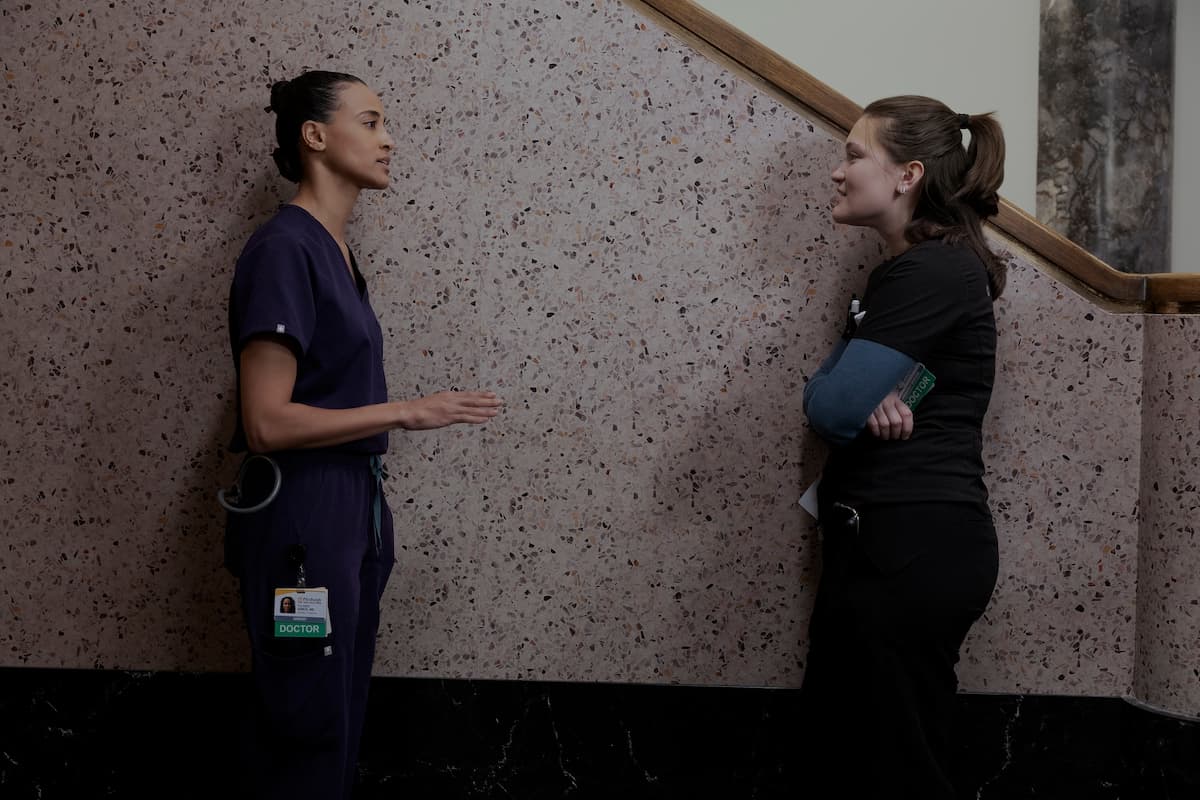 Two women talking in a stairwell. Garcia and Trinity Santos in The Pitt Season 2.