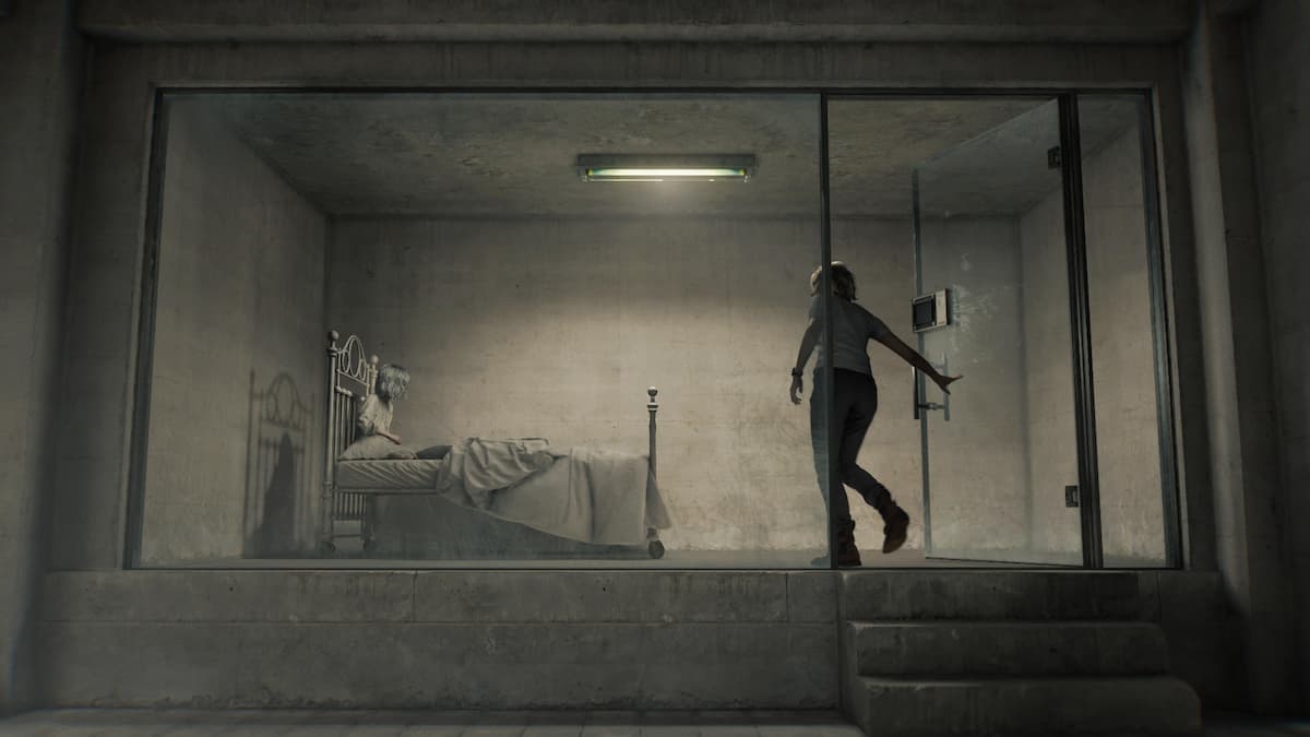 A woman entering a glass cell.