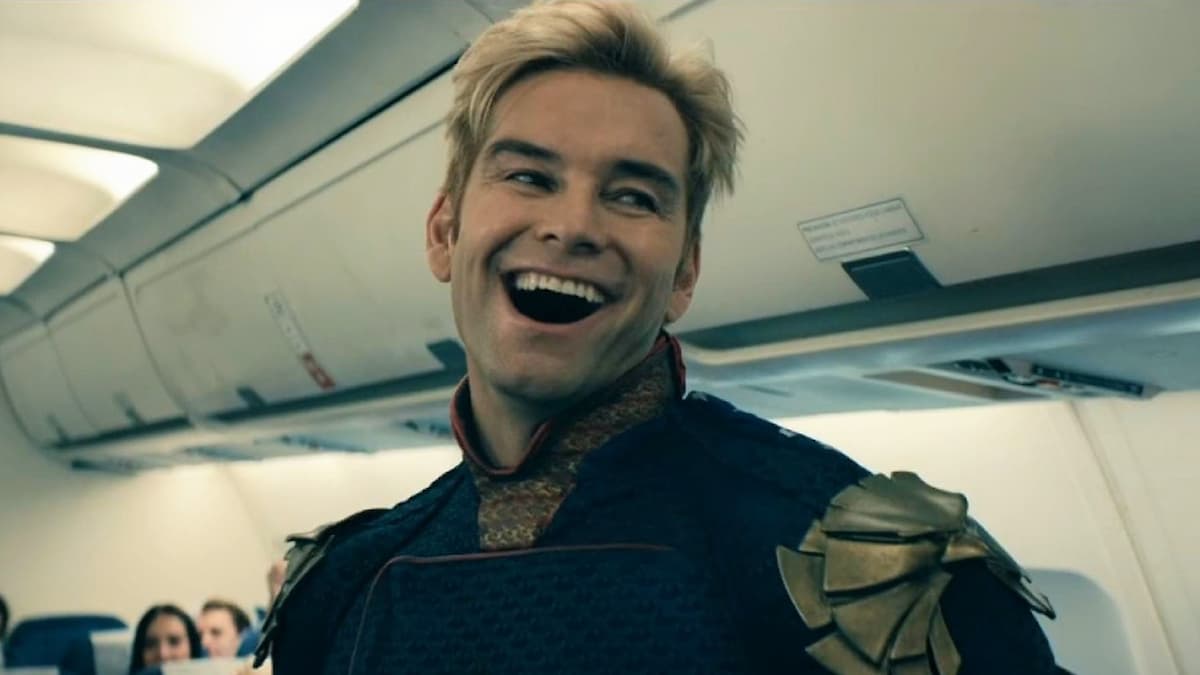 A man with blonde hair smiling on a plane. Homelander in The Boys Season 1.