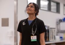 Supriya Ganesh Won’t Be in The Pitt Season 3 & I Am Devastated A doctor in black scrubs looking upwards and smiling. Supriya Ganesh in The Pitt.