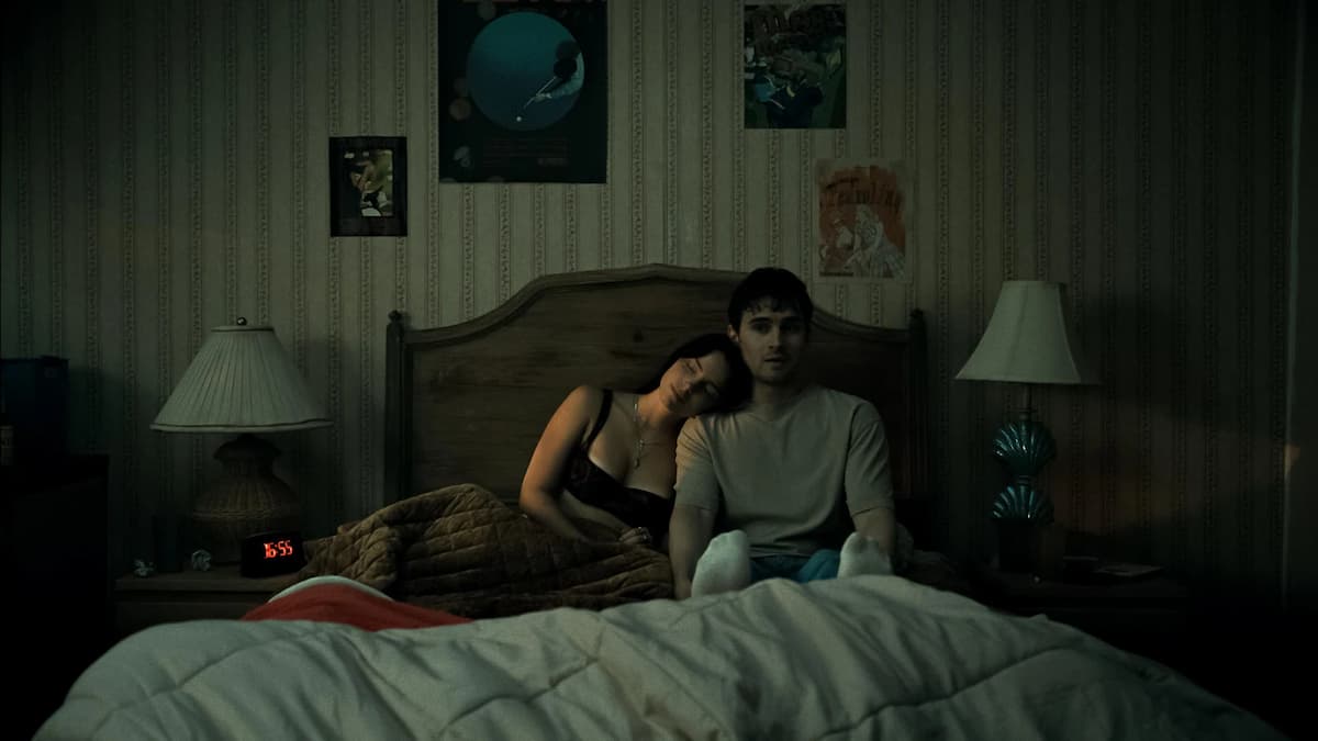 A woman and man in bed in the dark.